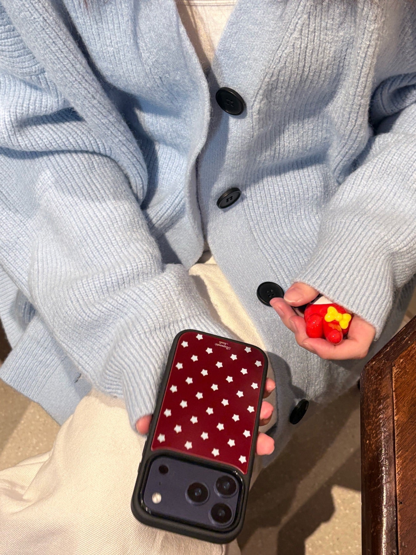 Dark red star phone case styled with a blue cardigan